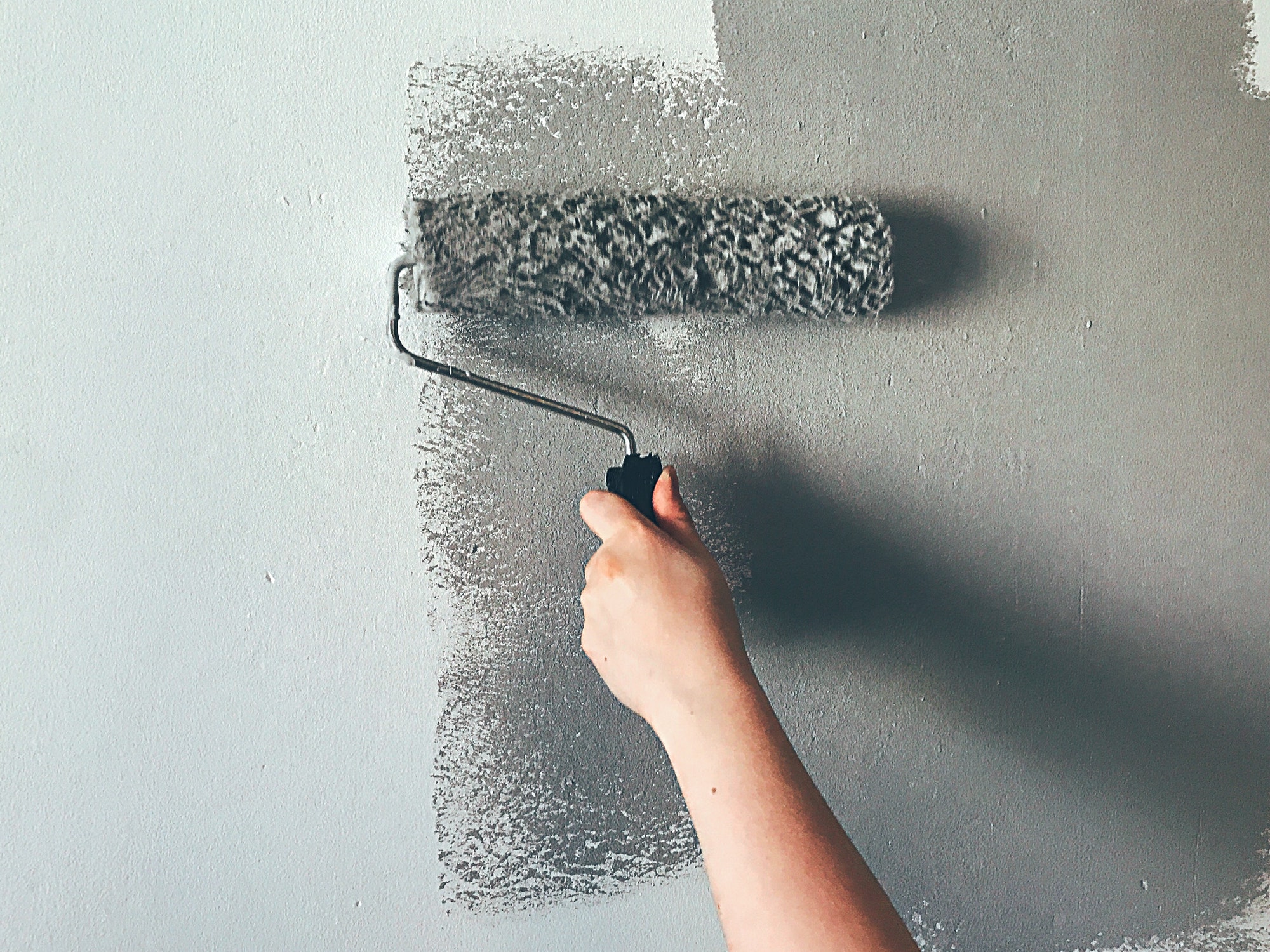 Woman painting wall with paint roller